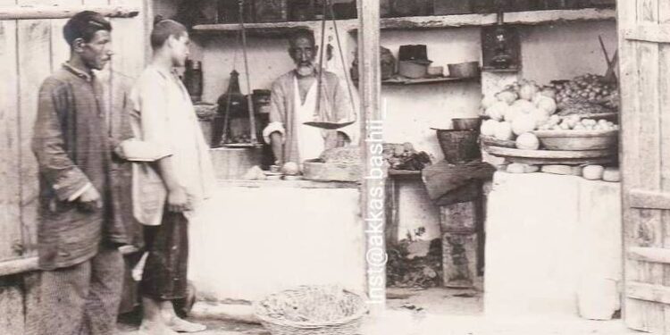 عکس یک میوه فروشی در تهران صد سال قبل، دست به سر کردن مشتری توسط مغازه دار!